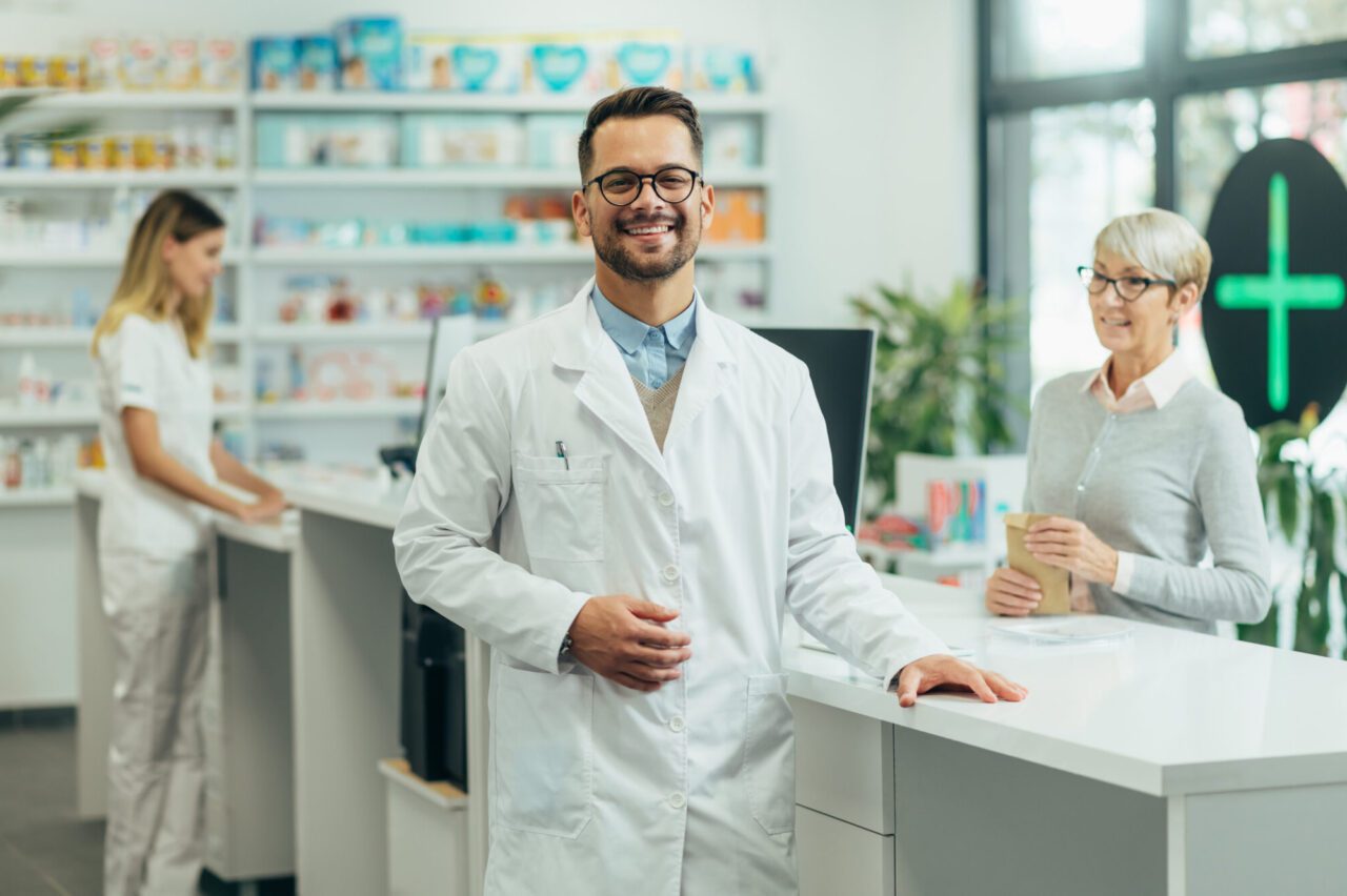 young-female-pharmacist-posing-while-working-in-a-pharmacy-e1697689073593